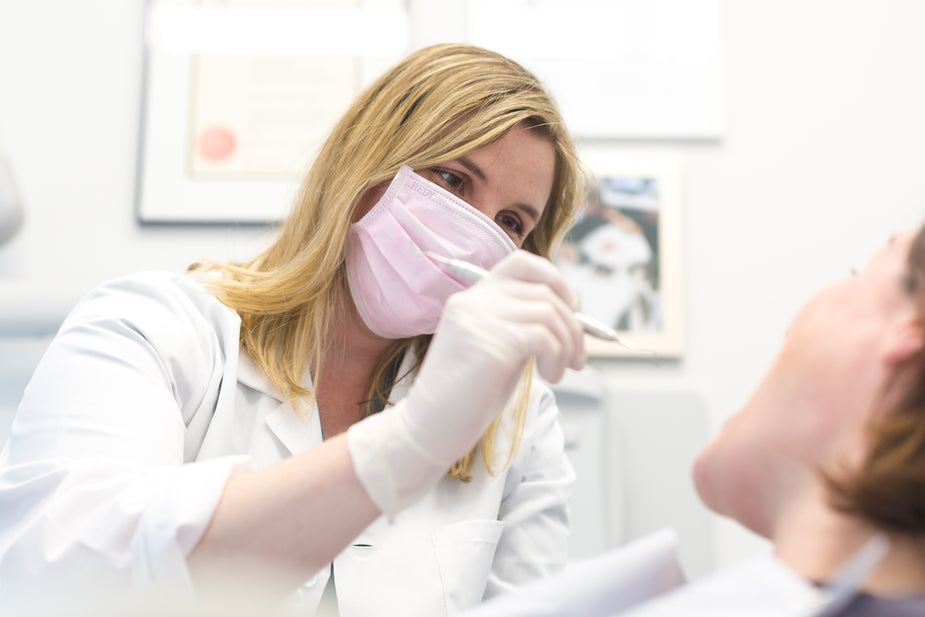 Dentist examining a patient to assess a loose dental crown during an appointment