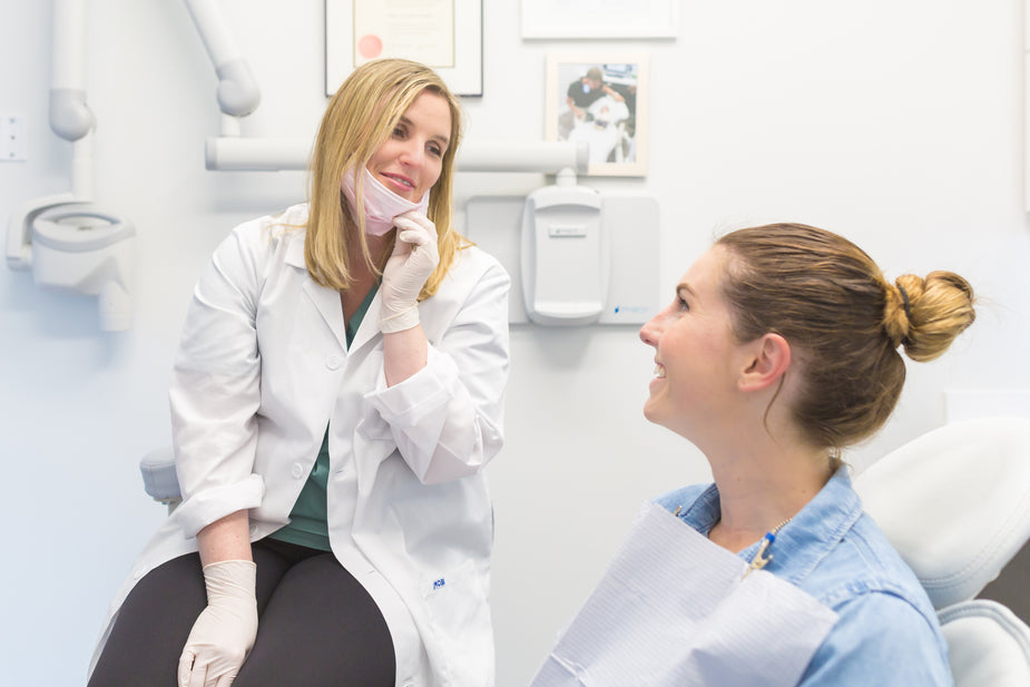 Dentist discussing a treatment plan and costs with a patient — private versus insurance-based dental care